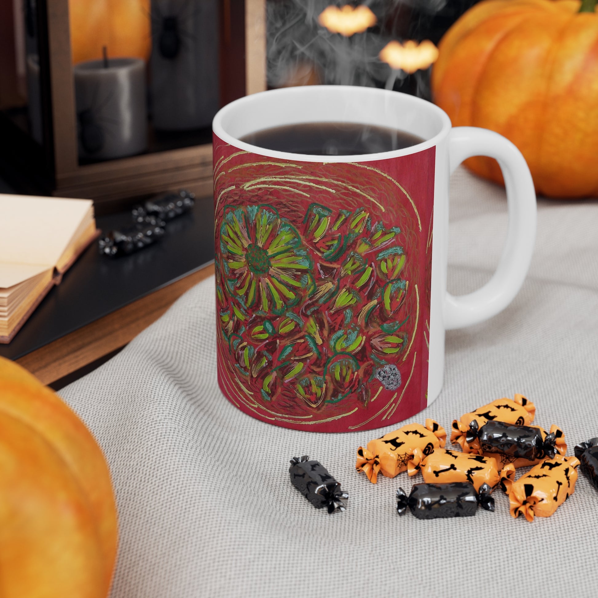 Mug with colorful design on a table with Halloween-themed treats and pumpkins.